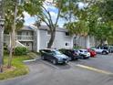 Gray condo building with parking lot and mature trees at 4154 Plantation Cove Dr # 408, Orlando, FL 32810