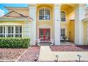Inviting front entrance of two-story house with red double doors and landscaping at 6607 Crestmont Glen, Windermere, FL 34786