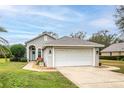 One story house with attached garage and a landscaped yard at 87 Twin Lake Cir, Umatilla, FL 32784