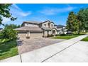 Large two story house with a paver driveway and mature trees at 9249 Ivywood St, Clermont, FL 34711