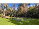 Serene backyard oasis featuring a pond and a wooden bench at 1600 Se 52Nd St, Ocala, FL 34480