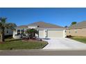 Two-story house with two-car garage and landscaped yard at 1881 Sassparilla Way, The Villages, FL 32162
