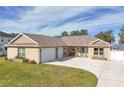 Two-car garage, front porch, and landscaped lawn at 3219 Landing Vw, Tavares, FL 32778