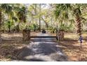 Property entrance with a black metal gate and stone pillars at 12359 Ne Highway 314, Silver Springs, FL 34488
