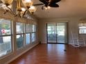 Dining area with hardwood floors, large windows, and sliding doors to a porch at 1021 Karney Dr, Lady Lake, FL 32159