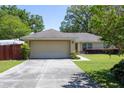 House exterior featuring a large beige garage and driveway at 5 Hemlock Terrace Pass, Ocala, FL 34472