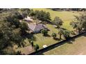 Aerial view showcasing a home with a spacious backyard and surrounding fields at 1801 Ne 77Th St, Ocala, FL 34479