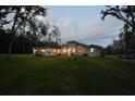 One-story house on a large lot with mature trees surrounding at dusk at 14950 Nw 216Th Pl, Micanopy, FL 32667