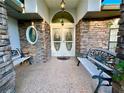 Front entry with stone facade, double doors, and benches at 7205 Ne 61St Avenue Rd, Silver Springs, FL 34488
