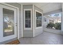 Front porch entry with tiled flooring and glass front door at 8360 Sw 65Th Ave, Ocala, FL 34476