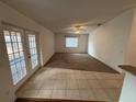 Spacious living room with tile and carpeted floors, and access to a patio at 9981 Sw 59Th Cir, Ocala, FL 34476