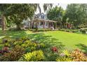 Two story home with wraparound porch, lush landscaping, and large yard at 350 E Park Ave, Lake Wales, FL 33853