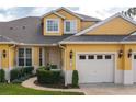 Yellow two-story home with two-car garage and landscaping at 3017 Mission Lakes Dr, Lakeland, FL 33803