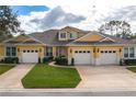 Two-story yellow home with three-car garage and landscaping at 3017 Mission Lakes Dr, Lakeland, FL 33803