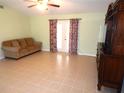 Living room with tiled floors, a sofa, and a TV stand at 914 Oxford Way, Lake Wales, FL 33853