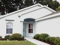 Well-maintained house with light-blue exterior, landscaping, and a walkway at 231 Lake Suzanne Dr, Lake Wales, FL 33859