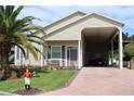 Tan house with carport and palm trees at 337 Motorcoach S Dr, Polk City, FL 33868