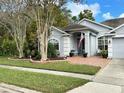 House exterior featuring gray siding, a two-car garage, and a brick patio at 141 Winghurst Blvd, Orlando, FL 32828