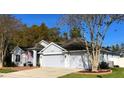 Two-story house with gray siding, a three-car garage, and a brick walkway at 141 Winghurst Blvd, Orlando, FL 32828