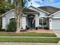 House exterior featuring gray siding, a two-car garage, and a brick patio at 141 Winghurst Blvd, Orlando, FL 32828