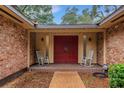 Front entry with double red doors and rocking chairs at 7510 Catherine Dr, Lakeland, FL 33810