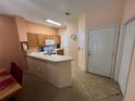 Kitchen with wood cabinets, white appliances, and breakfast bar at 8425 Crystal Cove Loop, Kissimmee, FL 34747