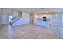 Open living room with tile floors and a view of the kitchen and stairs at 1417 Leamington Ln, Winter Haven, FL 33884