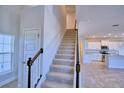 Staircase leading to the second floor, with kitchen view at 1417 Leamington Ln, Winter Haven, FL 33884