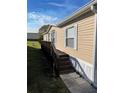 Side view of a tan mobile home with a deck at 50989 Highway 27 # 230, Davenport, FL 33897