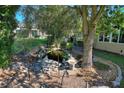 Serene backyard pond with a stone border, landscaping, and a bench at 360 Motorcoach S Dr, Polk City, FL 33868