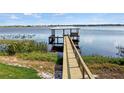 Wooden dock extending into lake with covered seating area at 274 Paradise Island Dr, Haines City, FL 33844