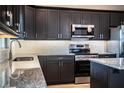 Modern kitchen with dark cabinets, granite countertops, and stainless steel appliances at 3671 E Gaskins Rd, Bartow, FL 33830
