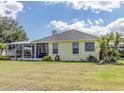 Yellow house with covered patio and lush landscaping at 745 Square Lake E Dr, Bartow, FL 33830