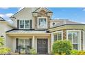 Two-story home with stone accents and rocking chairs at 1019 Ashton Woods Ln, Lakeland, FL 33813