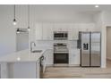 Modern kitchen with white cabinets, stainless steel appliances, and quartz countertops at 1024 Thompson Ave, Frostproof, FL 33843