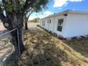 Side view of a white house with a yard and chain link fence at 143 D St, Lake Wales, FL 33853