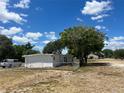 Side view of a white house with a yard and chain link fence at 143 D St, Lake Wales, FL 33853