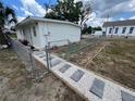 White house exterior with new walkway and chain link fence at 143 D St, Lake Wales, FL 33853