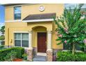 Front entrance of a yellow townhome with columns and a manicured landscape at 519 Sandstone St, Lakeland, FL 33809