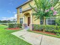 Well-maintained townhome with landscaping, a walkway, and a charming entrance at 519 Sandstone St, Lakeland, FL 33809