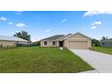 Tan house with a two-car garage and landscaping at 840 Voight N Ave, Fort Meade, FL 33841