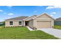 Tan house with a two-car garage and landscaping at 840 Voight N Ave, Fort Meade, FL 33841