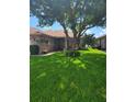 Brick house with lush lawn and large shade tree at 727 Martinique Cir, Lakeland, FL 33803