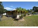 Side view of a tan house with palm trees and a chain link fence at 2646 Handley Blvd, Lakeland, FL 33803