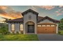 One-story home with a two-car garage, under sunset at 574 Loblolly Pl, Auburndale, FL 33823