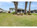 Home's backyard features a screened patio, landscaping, and spacious lawn at 2636 Huntington Hills Dr, Lakeland, FL 33810
