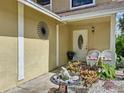 Front entrance with white door, two wicker chairs, and garden at 1426 Persimmon Way, Lakeland, FL 33811