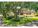 Two-story townhome with brown exterior and mature trees at 11 Loma Verde # 11, Lakeland, FL 33813