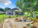 Backyard with deck, fire pit, and mature trees at 665 Lake Clark Pl, Lakeland, FL 33813