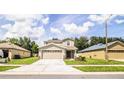 Two-story house with tan siding, two-car garage, and landscaping at 3926 Rollingsford Cir, Lakeland, FL 33810